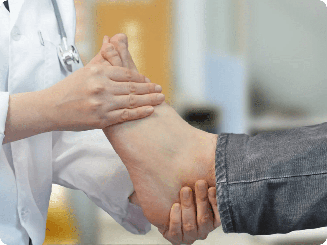 Doctor examining a patient's foot in a medical setting.