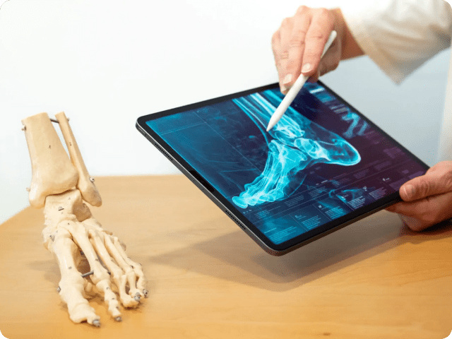 Medical professional analyzing a digital X-ray on a tablet.